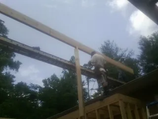 Carpenter setting a ridge beam over a new addition frame — Ice Dam Removal by Roofing Brothers in Cobbtown