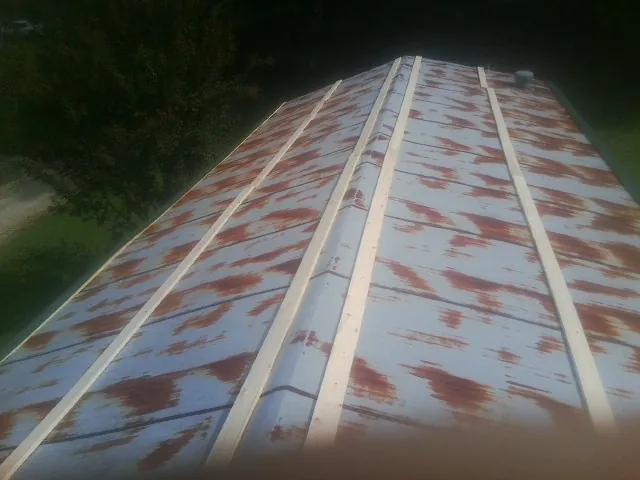 Rusted metal roof panels with new wood purlins before replacement — Storm Damage Roof Repair in Cobbtown by Roofing Brothers