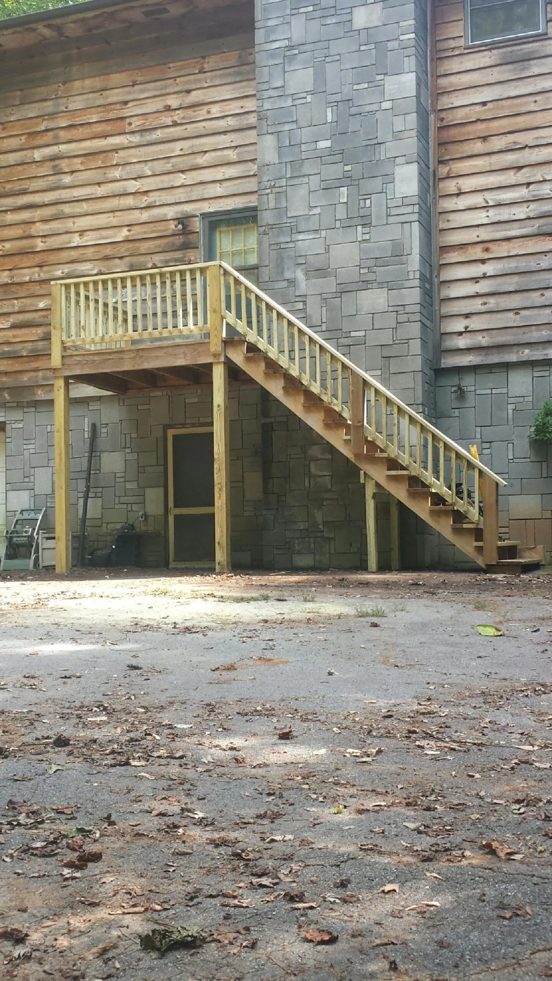 New pressure treated deck and stair landing on a log home in Cobbtown