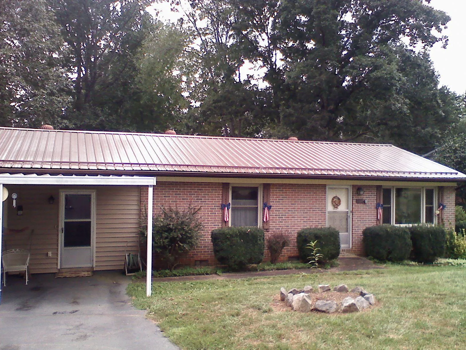 Bronze metal roof and carport on a brick ranch home — Roof Repair work by our crew in Cobbtown